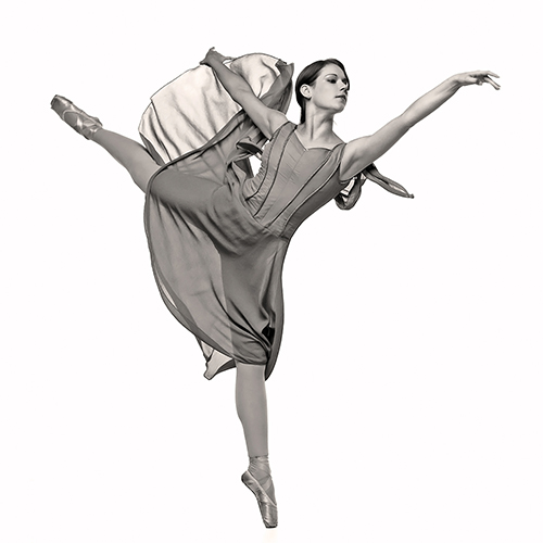 A ballerina gracefully performs a leap, extending her arm and leg elegantly. She wears a flowing dress and pointe shoes. The image is in black and white, highlighting the fluid movement and balance of the dance.